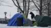Ante escasez de camas y bajas temperaturas, migrantes acampan frente a albergue de Nueva York
