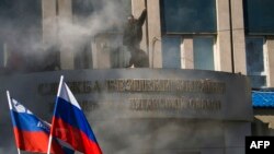 Para aktivis Pro-Rusia menggelar aksi demo di depan markas keamanan regional di Luhansk, Ukraina (6/4).