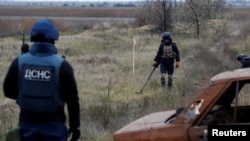 Українські сапери вишукують боєприпаси та міни, що не розірвалися, біля головної дороги до Херсона, Україна, 16 листопада 2022 року. За оцінками, третина від загальної площі України є потенційно небезпечними через замінування.REUTERS/Мурад Сезер