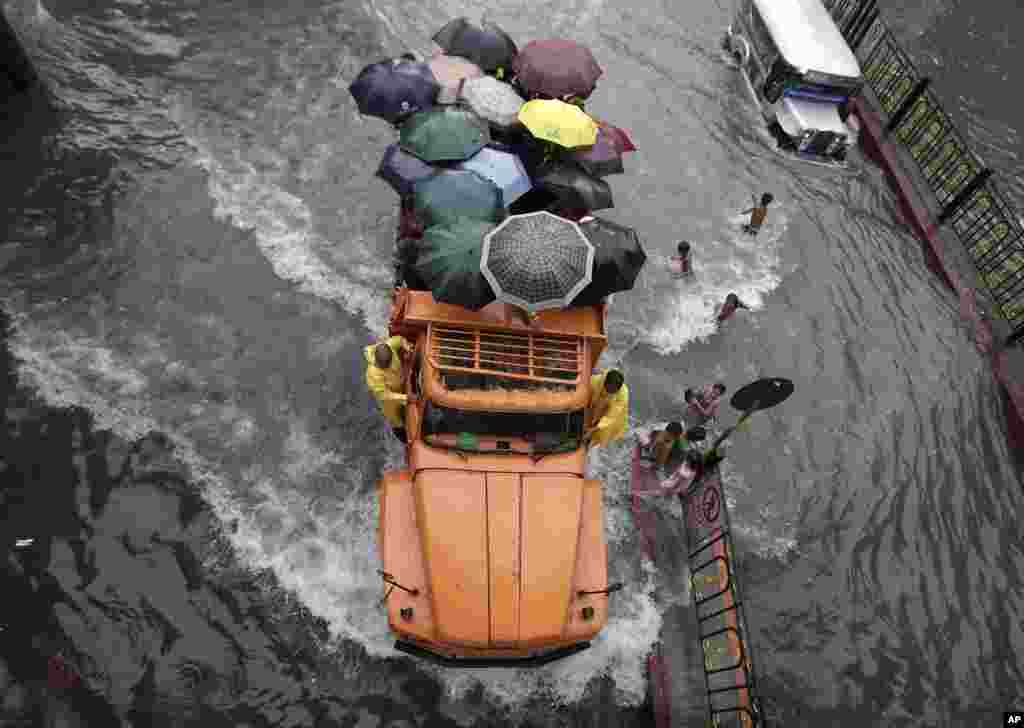 Sebuah truk penuh penumpang terjebak banjir di jalanan kota Manila, Filipina.