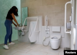 A tourist looks around a public toilet which was redesigned as part of a project to transform public toilets into restrooms that can be used comfortably by everyone, during a Tokyo Toilet Shuttle Tour, at Shibuya ward, in Tokyo, Japan April 4, 2024. (REUTERS/Kim Kyung-Hoon)