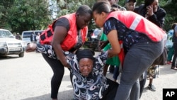 El personal de la Cruz Roja de Kenia ayuda a una mujer a reaccionar tras conocer que un miembro de su familia murió durante el ataque terrorista el miércoles, 16 de enero de 2019, en Nairobi, Kenia.
