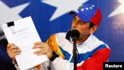 Henrique Capriles muestra documentos de impugnación de las elecciones presidenciales del pasado abril. Un petitorio fue presentado este lunes ante la CIDH.