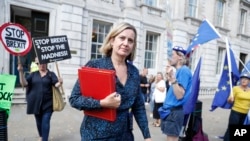 Anggota parlemen Inggris, Amber Rudd, melewati beberapa pengunjuk rasa anti-Brexit saat meninggalkan kantornya di London, 2 September 2019.