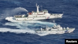 Tampak dalam gambar yang diambil dari udara, sebuah kapal pengawal pantai Jepang (bawah) beradu semprot dengan kapal pengawal pantai Taiwan yang mengawal puluhan kapal nelayan Taiwan berlayar melewati perairan dekat pulau sengketa di Laut China Timur (25/9). 