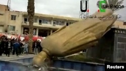 A statue of President Bashar Al-Assad's father, Hafez Al-Assad, is pulled down as people celebrate in Raqqa Mar. 4, 2013.
