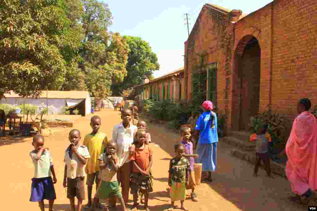 Young IDPs play in front of church buildings at the St. Mary Help of Christians Cathedral in Wau, Western Bahr el Ghazal, Dec. 8, 2016. (VOA/Jill Craig)
