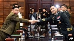 14일 한국 경기도 파주 판문점 북측 통일각에서 열린 장성급 군사회담에서 김도균 남측 수석대표(오른쪽)와 안익산 북측 수석대표가 악수를 하고 있다. 