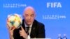 ARCHIVO - El presidente de la FIFA, Gianni Infantino, sostiene un balón de fútbol mientras habla durante una conferencia de prensa después de la reunión del Consejo de la FIFA, el viernes 15 de marzo de 2019, en Miami.