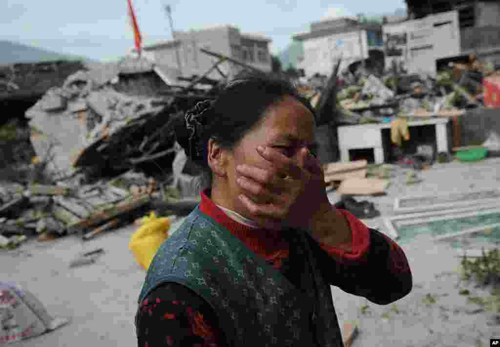 Reaksi seorang perempuan saat melihat rumahnya yang hancur akibat gempa bumi yang melanda wilayah Lushan, Ya'an, propinsi Sichuan, 20 April 2013.