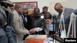 Tanzanian Minister for Finance and Planning Philip Mpango, center, and other government officials look at diamonds seized at the airport in Dar es Salaam, Tanzania, Sept. 9, 2017.