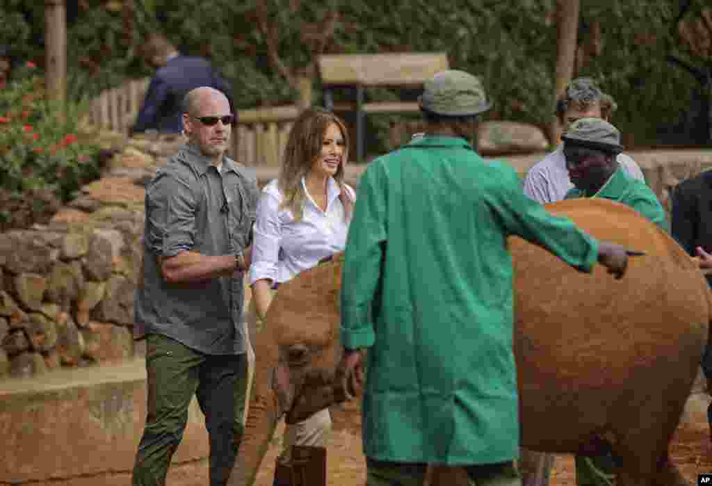 A Secret Service agent, left, holds U.S. first lady Melania Trump to protect her as she steps backwards after being nudged by a baby elephant she petted, at the David Sheldrick Wildlife Trust elephant orphanage in Nairobi, Kenya Oct. 5, 2018.