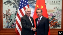 美国国务卿蒂勒森（左）与中国外交部长王毅（右）在人民大会堂会面前握手。（2017年9月30日）