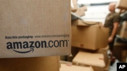 FILE- An Amazon.com package awaits delivery by UPS in Palo Alto, California, Oct. 18, 2010. With its stock price topping $1,000, the e-commerce giant now has a market value of $478 billion, double that of rival Wal-Mart.