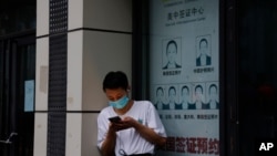 FILE - A resident stands near a shuttered store in Chengdu, China, July 25, 2020. Officials announced a lockdown of the city's 21.2 million residents on Sept. 1, 2022, because of a COVID-19 outbreak. Chengdu's Health Commission reported 665 confirmed cases as of Aug. 31, 2022.