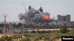 FILE - Smoke and flame rise after what fighters of the Syria Democratic Forces said were U.S.-led airstrikes on the mills of Manbij where Islamic State militants are positioned, in Aleppo Governorate, Syria, June 16, 2016. 