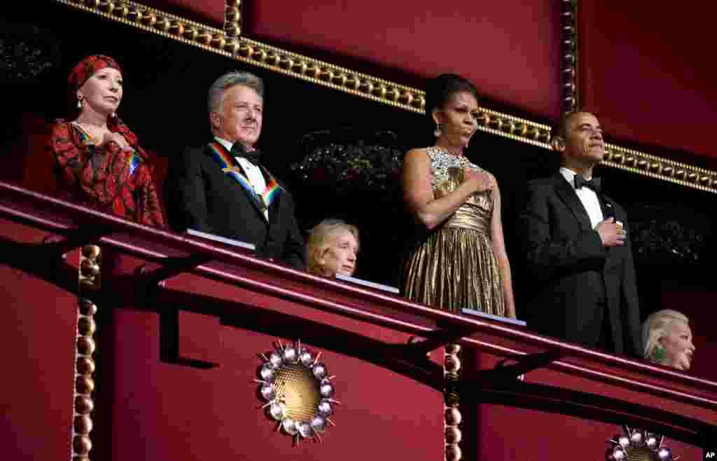 El presidente Barack Obama y su esposa Michelle entonan el himno de EE.UU. durante la ceremonia de la entrega de premios a las artes del Kennedy Center. Acompañan a la pareja presidencial el actor Dustin Hoffman y la bailarina Natalia Makarova.
