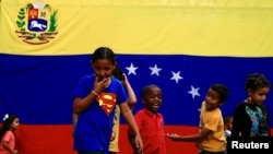 Niños juegan frente a la bandera de Venezuela en Caracas, Venezuela. Setiembre 7, 2019. Foto: REUTERS.