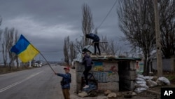 Згідно з опитуванням, 74% українців вважають, що Україна поверне всі свої території. На фото –українські діти, які граються на покинутому блокпосту в Херсоні, після відступу з міста російських окупаційних військ. Південна Україна, середа, 23 листопада 2022 року. (AP Photo)