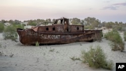A rusting ship sits in a dried-up area of the Aral Sea in Muynak, Uzbekistan, Sunday, June 25, 2023. (AP Photo/Ebrahim Noroozi)