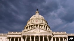 FILE - Dark clouds pass over the Capitol in Washington.