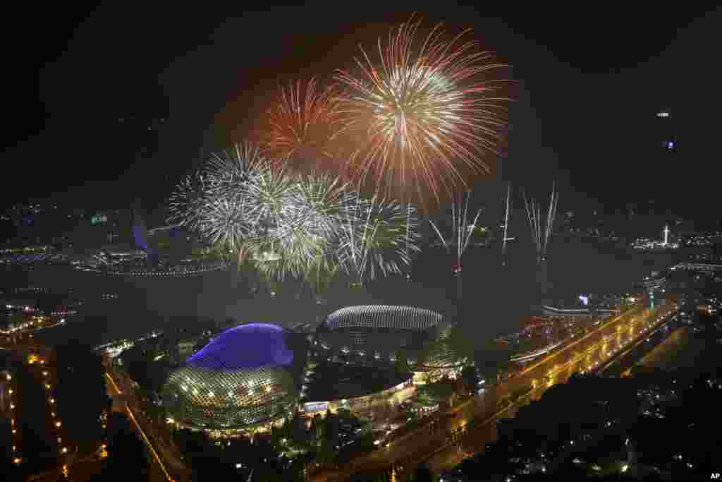 Fireworks explode above Singapore's financial district at the stroke of midnight to mark the New Year's celebrations, Jan. 1, 2018, in Singapore.
