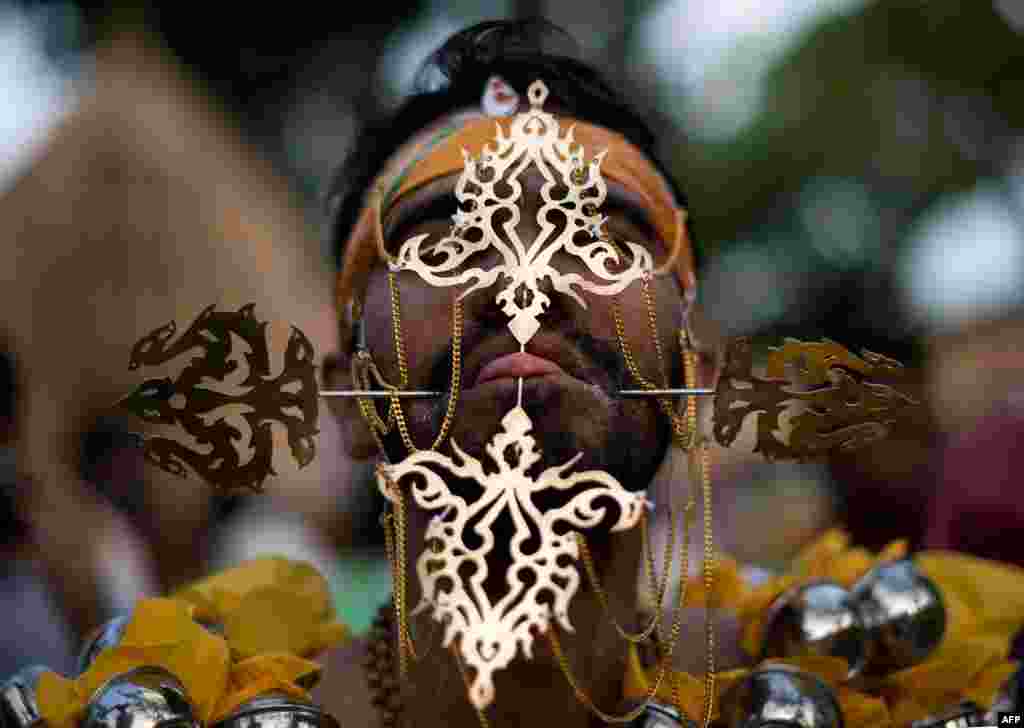 Seorang penganut Hindu menusuk lidahnya sebelum memasuki kuil di Puncak Lereng Murugan dalam perayaan tahunan Thaipusam yang penuh warna. Festival yang merupkan salah satu perayaan keagamaan yang diwarnai dengan hal-hal yang paling ekstrim di dunia sebagai tanda bakti terhadap agama ini, dilaksanakan di Georgetown, Pulau Penang, Malaysia.