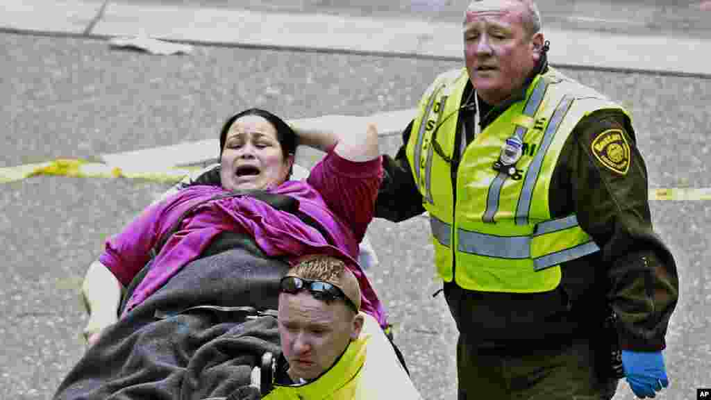 Paramédicos ajudam uma senhora ferida junto à linha de chegada da maratona de Boston ( 15 Abril de 2013).