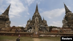 FILE - Tourists walk at the ruins of the ancient capital of Ayutthaya, Thailand, Dec. 25, 2015. International tourist arrivals in Thailand are expected to reach a record high in 2016, the tourism minister said on Jan. 6, 2016, after nearly 30 million foreigners came to its temples, beaches and bars in 2015. 