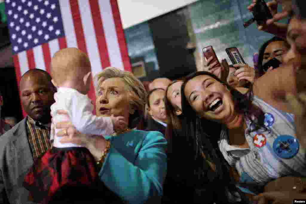 Capres Partai Demokrat Hillary Clinton menggendong seorang bayi saat kampanye di kota Lake Worth, Florida.