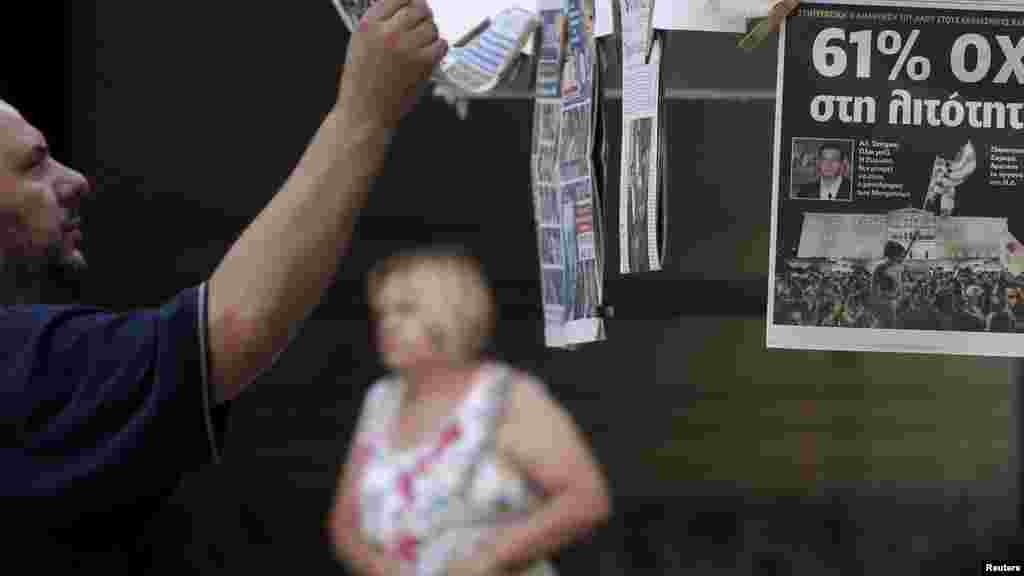 Un homme regardant les journaux suite au référendum à Athènes, en Grèce