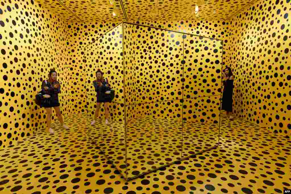 Visitors stand inside an installation by Japanese artist Yayoi Kusuma titled 'The Spirits of the Pumpkins Descended into the Heaven' at National Gallery Singapore.