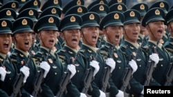FILE - Soldiers of People's Liberation Army march in formation past Tiananmen Square during the military parade marking the 70th founding anniversary of People's Republic of China, on its National Day in Beijing, Oct. 1, 2019.