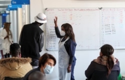 A health worker talks to a vaccine trials' volunteer before he is tested for COVID-19 and takes part of the country's human clinical trial for potential vaccines at the Wits RHI Shandukani Research Centre in Johannesburg, South Africa, Aug. 27, 2020.