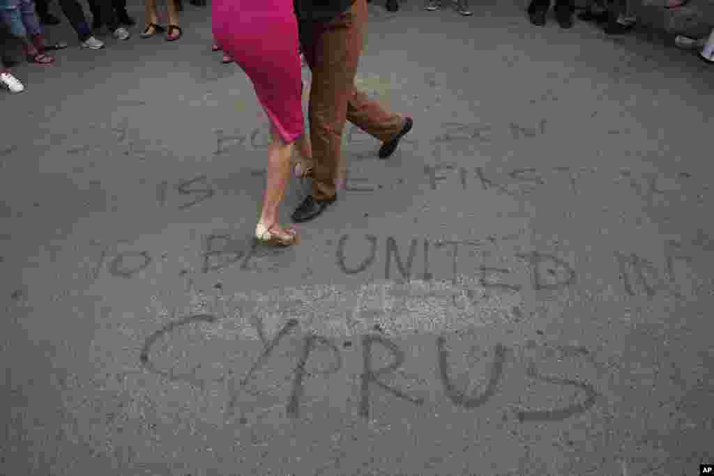 Greek and Turkish Cypriots dance a tango inside the United Nations-controlled buffer zone along Ledra Street in the medieval center of Cyprus' divided capital Nicosia. The dancers gathered as part of a demonstration in support of talks aimed at reunifying the ethnically-divided island.