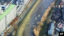 In this image made off a video released by Miyagi Prefectural Police, water rushes up Sunaoshi river in Tagajo, Miyagi prefecture, Nov. 22, 2016.