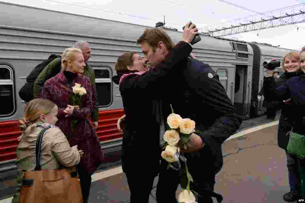 Pemimpin oposisi Rusia Alexei Navalny (tengah, kanan) disambut oleh para pendukung dan isterinya Yulia di sebuah stasiun kereta api di Moskow, setelah pengadilan Rusia menangguhkan hukumannya.