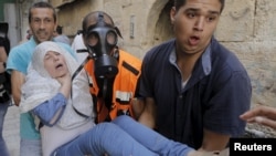 Seorang perempuan Palestina dievakuasi oleh petugas medis di tengah bentrokan antara pelempar batu Palestina dan polisi Israel di kota tua Yerusalem (15/9). (Reuters/Ammar Awad)