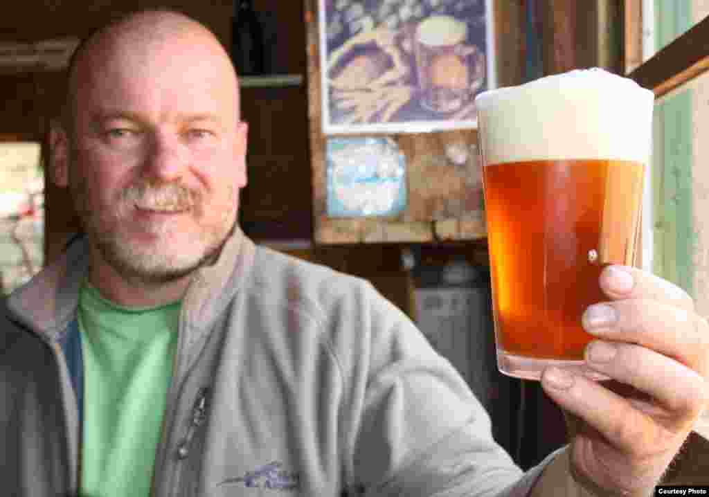 Dirk van Tonder of South Africa admires a freshly poured ‘African pale ale’ that he brewed using a hop so new it is only known as the J-17-63 hop. (VOA/Darren Taylor)