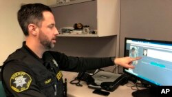 FILE - Washington County Sheriff's Office Deputy Jeff Talbot demonstrates how his agency used facial recognition software to help solve a crime, at their headquarters in Hillsboro, Oregon, Feb. 22, 2019.