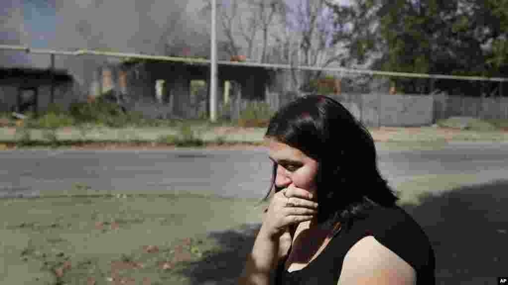 A local woman sits and cries in front of her burning house after shelling in Donetsk, eastern Ukraine, Sept. 7, 2014.