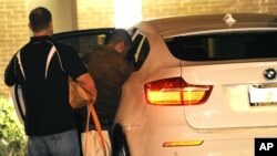 George Zimmerman, derecha, sube a un BMW junto a una persona no identificada. Zimmerman salió libre la medianoche del domingo.
