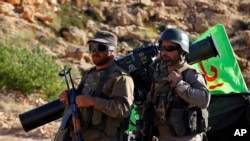 Pejuang Hezbollah berdiri dekat kendaraan militer di lokasi pertempuran antara Hezbollah dan pejuang dukungan al-Qaida di Wadi al-Kheil atau Lembah al-Kheil di perbatasan Lebanon-Suriah, 29 Juli 2017.