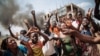 Les manifestants crient à côté d'un barrage routier au milieu de l'avenue principale de Beni lors d'une manifestation contre le report des élections sur le territoire des Beni et de la ville de Butembo le 27 décembre 2018.