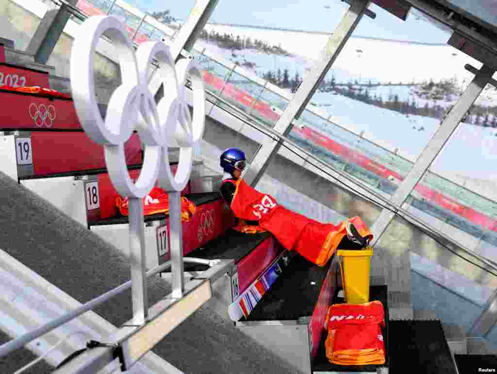 Kobayashi Ryoyu of Japan sits under a blanket as he waits to compete in men's ski jumping during the 2022 Beijing Olympics, at the National Ski Jumping Centre, in Zhangjiakou, China.