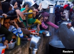 Anak-anak Palestina menunggu untuk menerima makanan selama bulan suci Ramadhan di Rafah, di Jalur Gaza selatan, 13 Maret 2024. (Foto: REUTERS/Mohammed Salem)