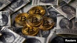 Bitcoin (virtual currency) coins placed on Dollar banknotes are seen in this illustration picture, Nov. 6, 2017. 
