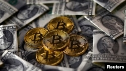 FILE - Bitcoin (virtual currency) coins placed on Dollar banknotes are seen in this illustration picture, Nov. 6, 2017. 