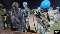 Esta fotografía difundida el 26 de enero de 2025 por el Ejército uruguayo muestra a soldados de las Fuerzas Armadas de la República Democrática del Congo entregando sus armas a soldados uruguayos de la Misión de Estabilización de la ONU en Goma, República Democrática del Congo.