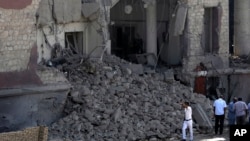 Egyptian policemen stand at the base of the crumbled facade of the Italian consulate following a blast that killed at least one person in Cairo, Egypt, July 11, 2015. 